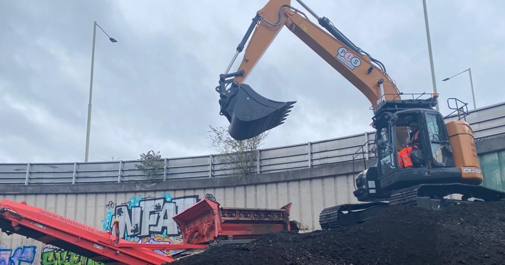Excavator atop of spoil heap.